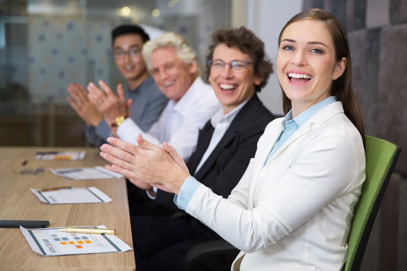 Executivos aplaudindo em uma sala de reuniões