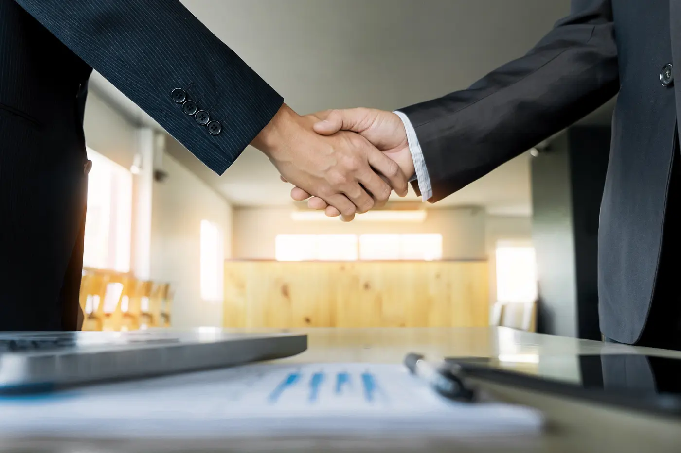Dois executivos apertando as mãos após uma negociação